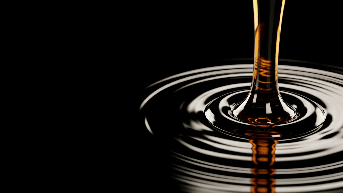 Dark amber liquid pouring into reflective oil-like ripples