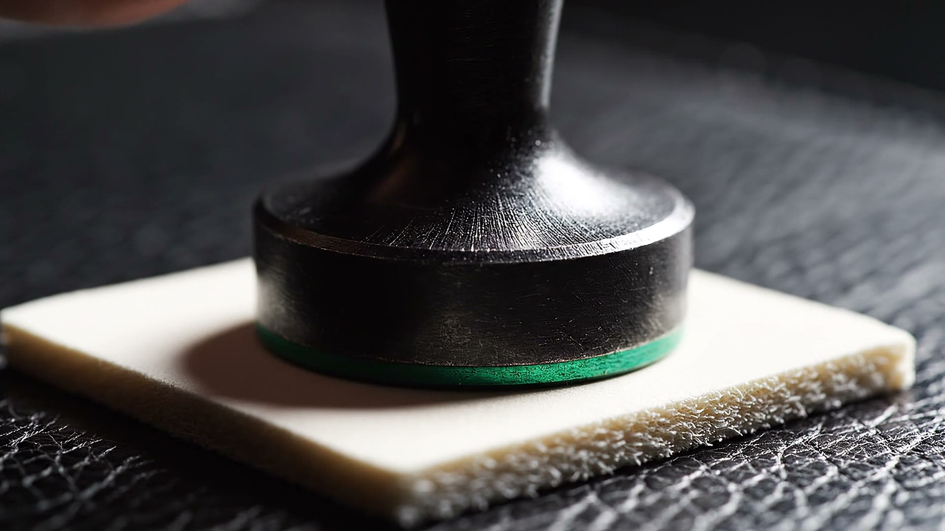 A stamp held over a blank blotter — practice the ticket first